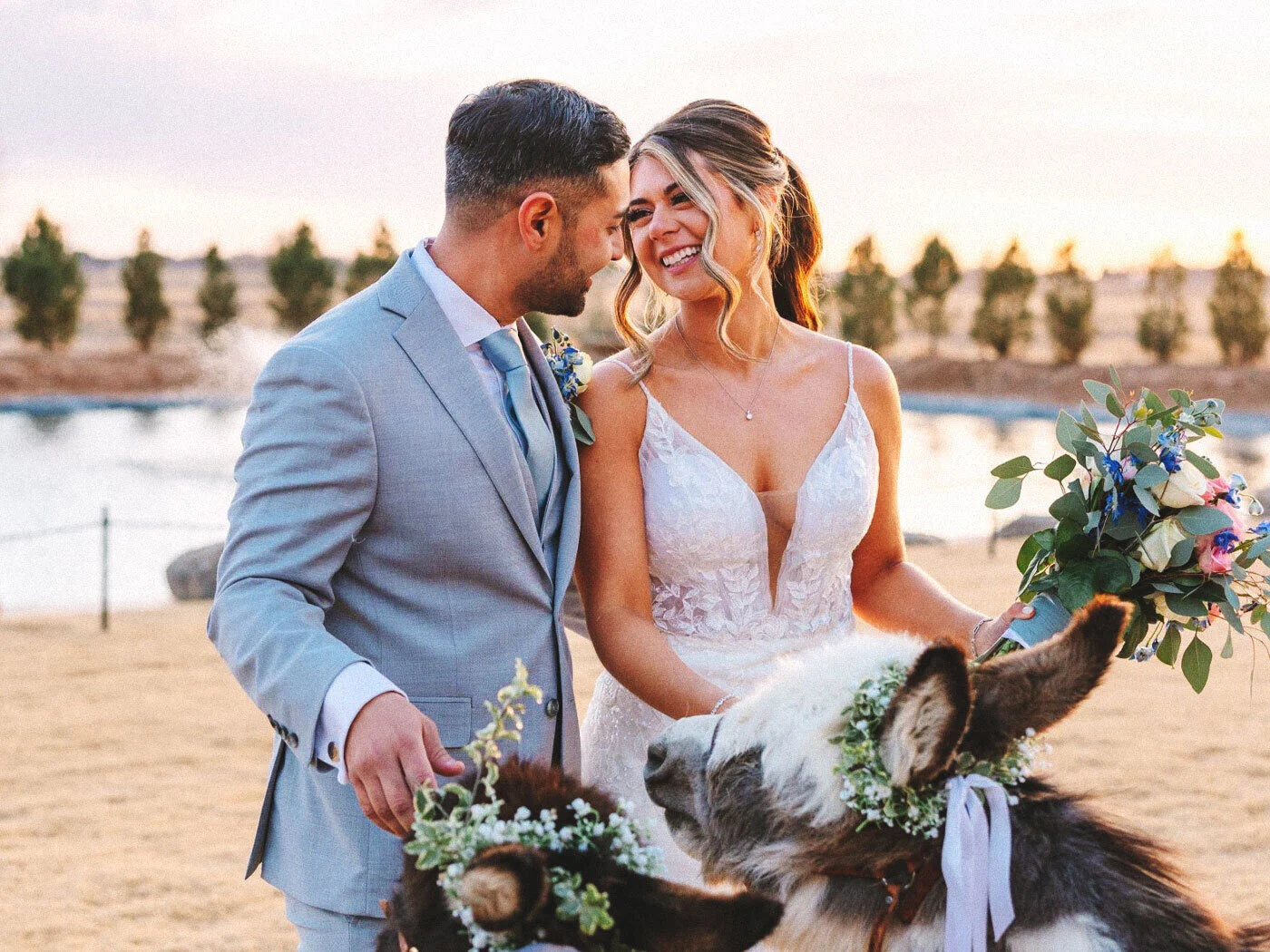 A bride and groom laughing with a flower-crowned donkey at Madewell Estates